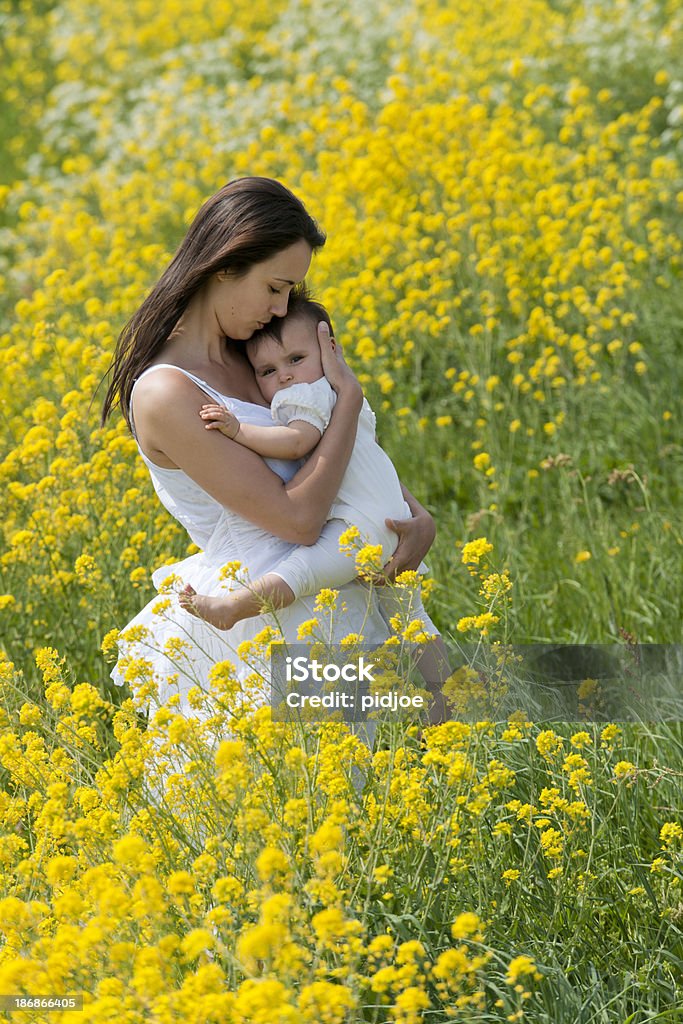 Mãe segurando bebê Menina no campo de Flores - Royalty-free Abraçar Foto de stock