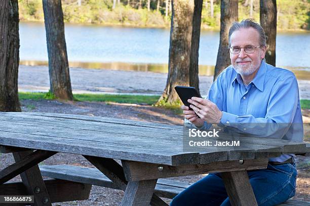 Senior Man And Ebook Stock Photo - Download Image Now - Men, Picnic Table, Bench