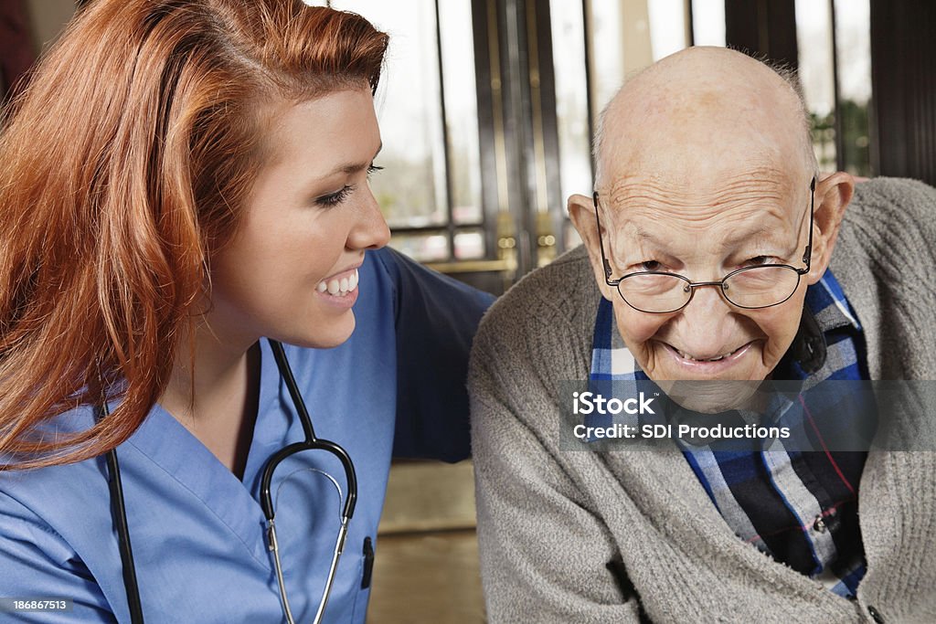 Feliz enfermeira com adulto homem sênior - Foto de stock de 70 anos royalty-free