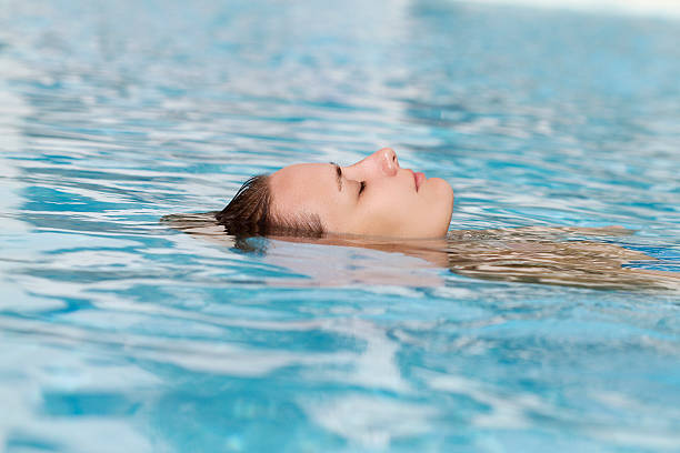 istock woman relaxing in swimming pool 186867800