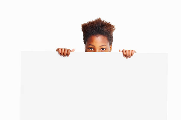 istock Isolated kid holding blank billboard looks at you - copyspace 186867990