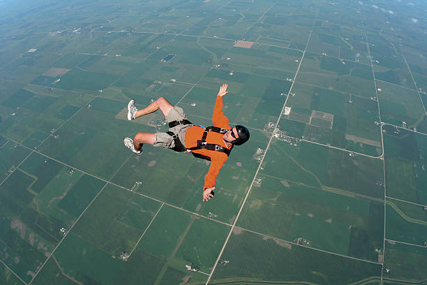 royalty free banco de fotos: homem em queda livre nas costas - skydiving parachute parachuting taking the plunge - fotografias e filmes do acervo