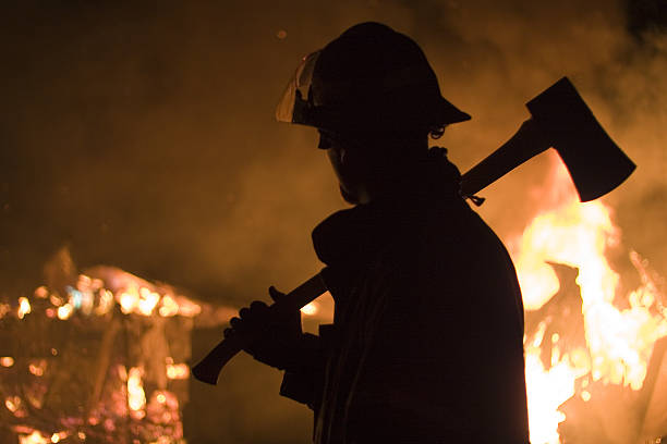 istock Silhouette of a firefighter with an axe and a fire 186868581