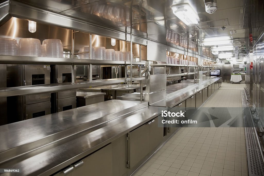 Large commercial kitchen Stainless steel modern commercial kitchen. Clean polished worktops, cupboards, shelves and plate covers. Commercial Kitchen Stock Photo