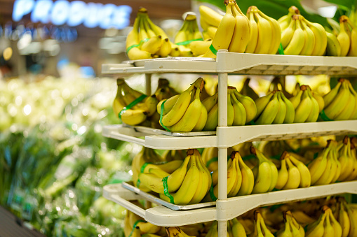 A bunch of bananas is neatly displayed on a rack for sale at a grocery store.