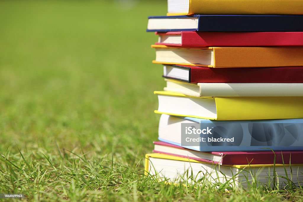 Stack of Books on Grass Close-up of colorful books stacking on grass field.Similar images - Book Stock Photo