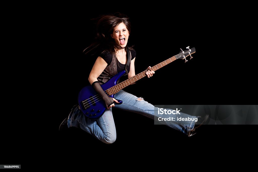 Feliz niña de salto de balancín con guitarra sobre fondo negro Bass - Foto de stock de Guitarra eléctrica libre de derechos