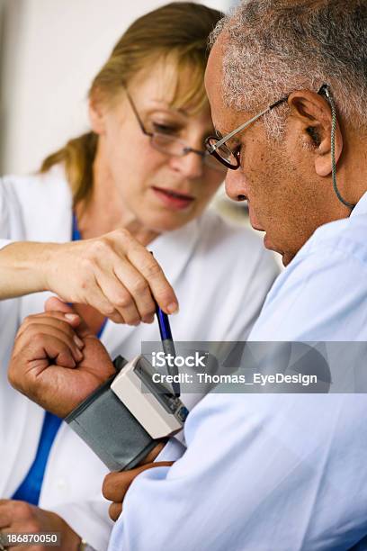 Médico Verificar A Pressão Arterial Do Paciente Dela - Fotografias de stock e mais imagens de Medidor de Tensão Arterial