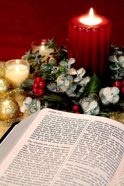 istock Religious: Christmas open to Bible scripture and red Candle 186870714