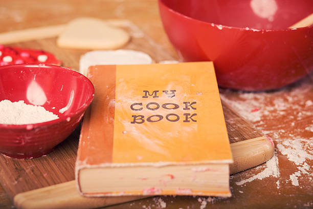 Valentine's Day cookies displayed with a child's cookbook. Selective focus.