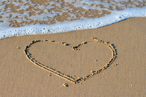 Drawing a heart on the beach.