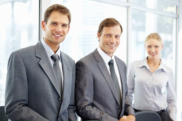 istock Handsome business man smiling with colleagues in a row 186872543
