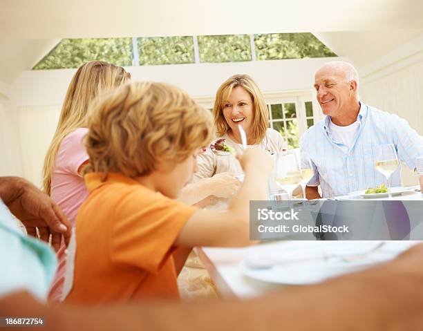 Tucking En Una Familia Feast Foto de stock y más banco de imágenes de Abuela - Abuela, Abuelo, Abuelos