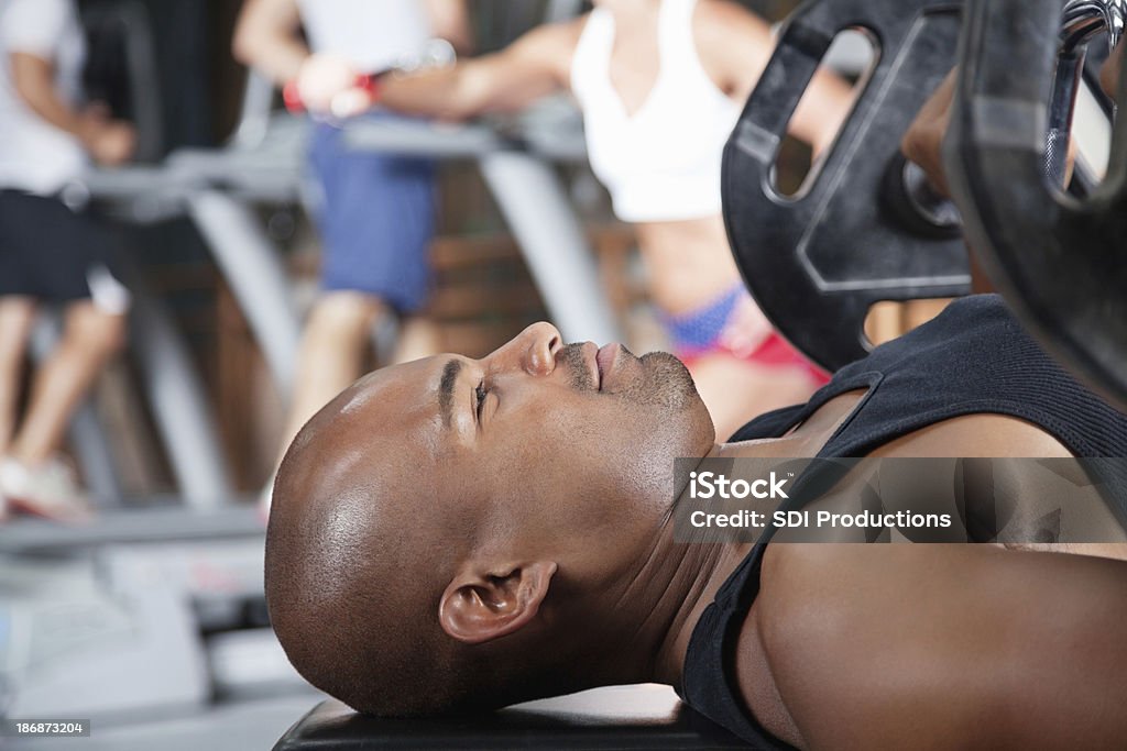 Starke junge Mann Gewichtheben Hantelbank im Fitnessraum - Lizenzfrei Afrikanischer Abstammung Stock-Foto