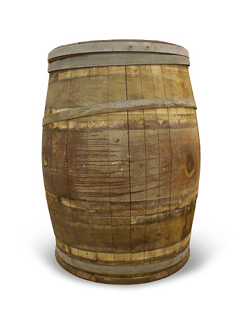 An antique wooden barrel placed on a rustic porch, near a window