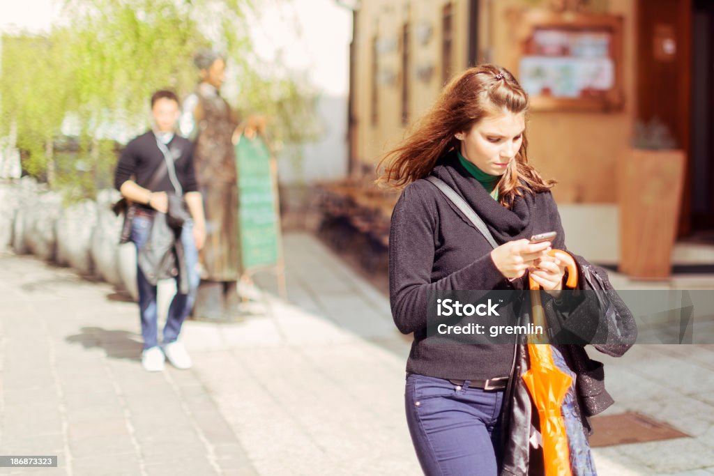 Jeune femme à envoyer des SMS sur son téléphone mobile - Photo de Adulte libre de droits