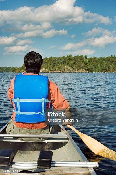 Uomo In Canoa Sul Bordo Il Confine Innaffia Area Di Canoa Vt - Fotografie stock e altre immagini di Persone