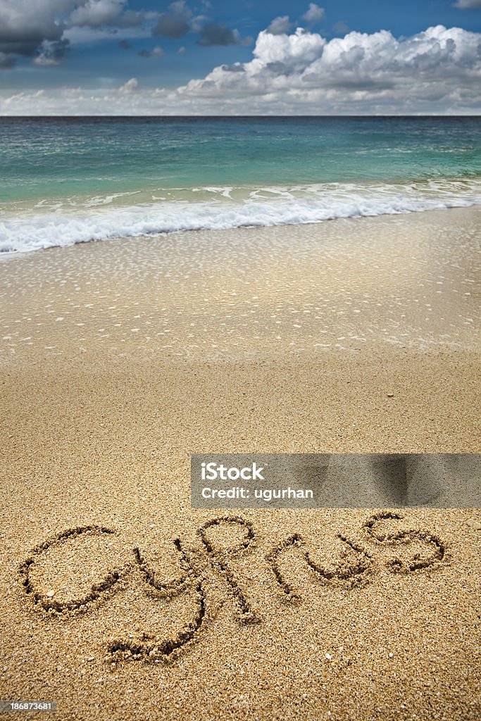 Cyprus written Cyprus written in brown sand with frothy white waves. Beach Stock Photo