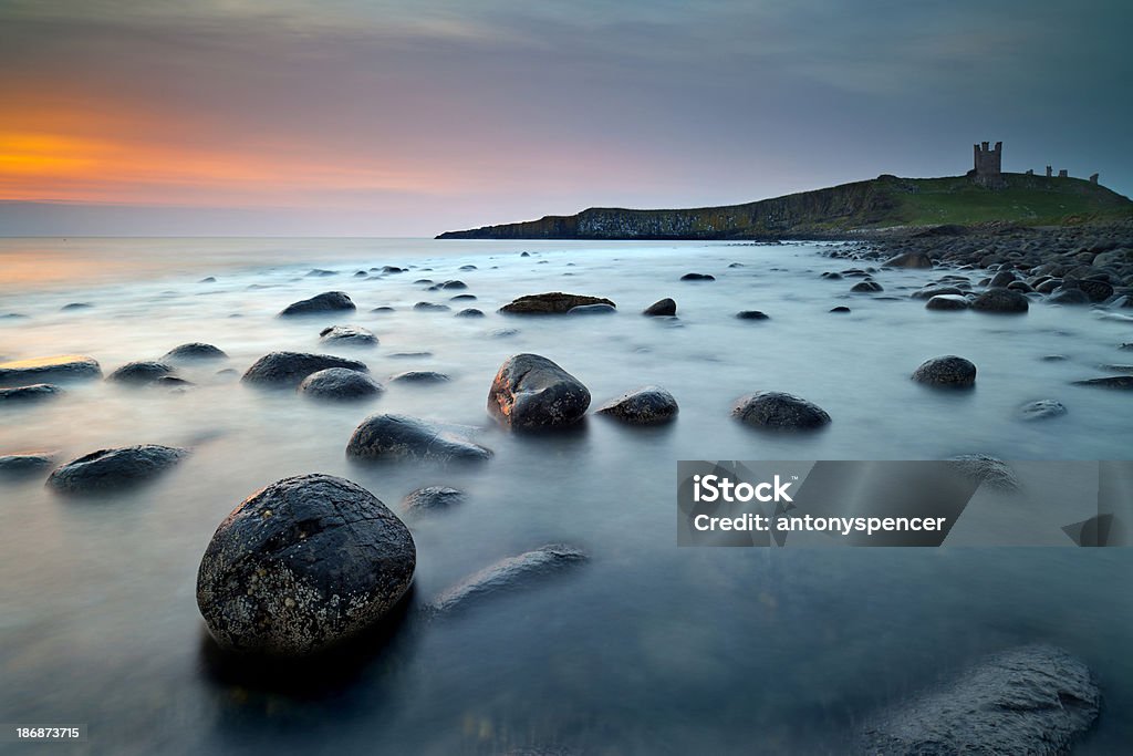 Castello di Dunstanburgh all'alba. - Foto stock royalty-free di Northumberland