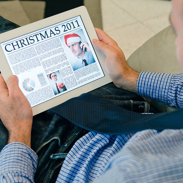 istock Man holding a digital tablet with christmas newspaper 186874120