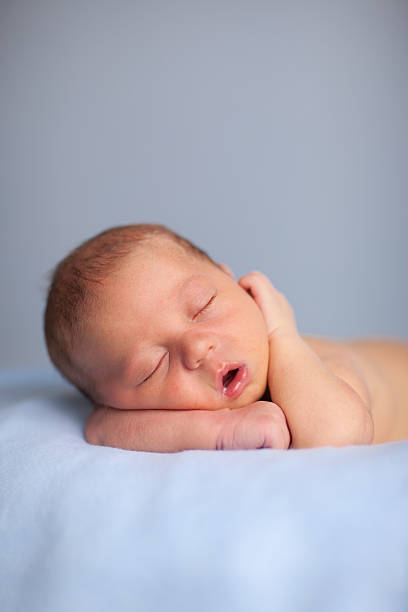 Newborn Baby Boy Sleeping Peacefully on Blue Blanket