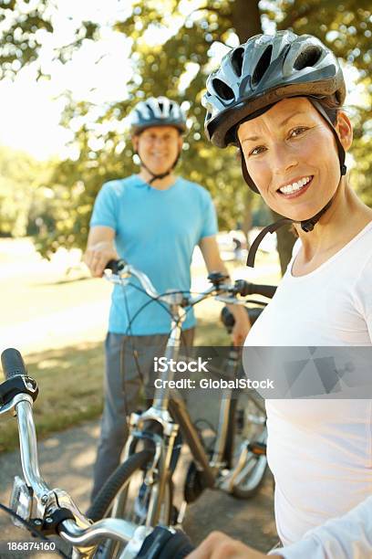 Homem E Mulher Sorridente Com Bicicletas - Fotografias de stock e mais imagens de 40-49 Anos - 40-49 Anos, Adulto, Adulto maduro