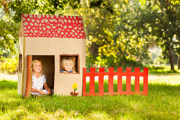 Children Sitting In Playhouse Portrait of happy little children sitting in playhouse. Horizontal Shot. Please checkout our lightboxes  kids play house stock pictures, royalty-free photos & images