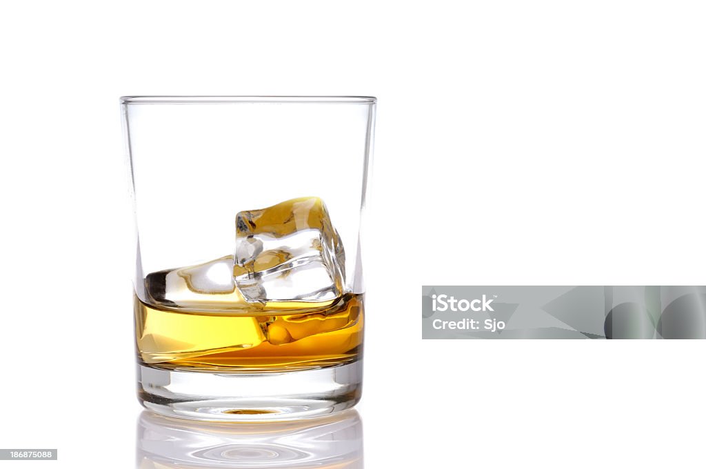 Glass of whisky Glass of whisky or whiskey with ice isolated. Reflection in the foreground. Whiskey Stock Photo