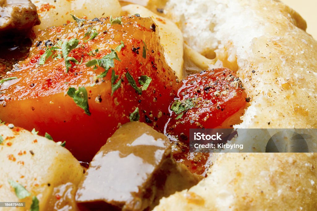 Stew in Bread Bowl "Delicious beef stew with carrots, potatoes and tomatoes in a bead bowl.  Close-up" Beef Stock Photo