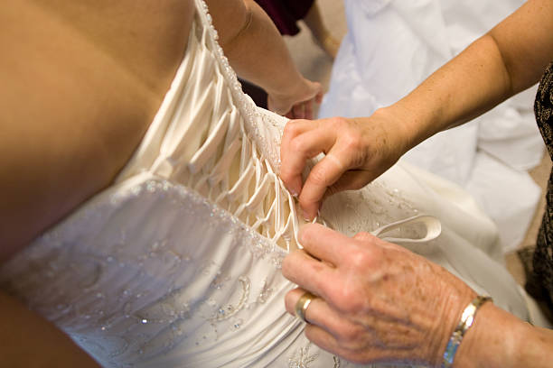 istock older woman's hands lacing blide's white corset beaded wedding dress 186875865