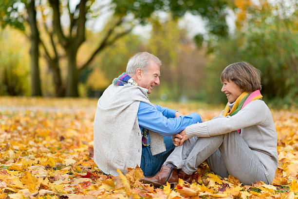 istock Senior couple sitting on floor in park 186876146