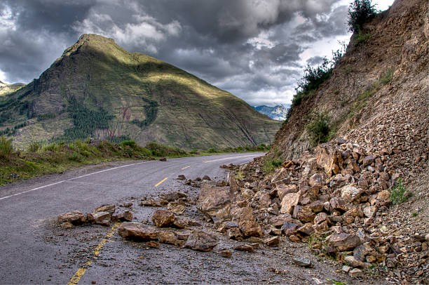 Rock slide with damage on the road during a storm