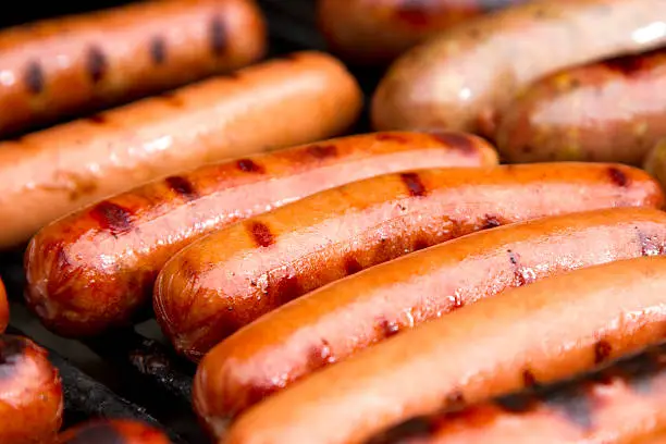 Juicy hot dogs on the grill.