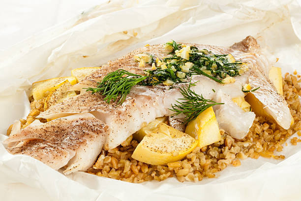 blanc poisson cuisson en papillote avec freekeh le dîner - crookneck squash photos et images de collection