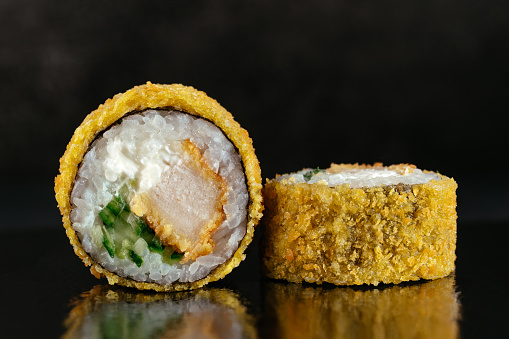 Deep-fried Japanese sushi rolls on a dark background with reflec in Tokyo, Tokyo, Japan