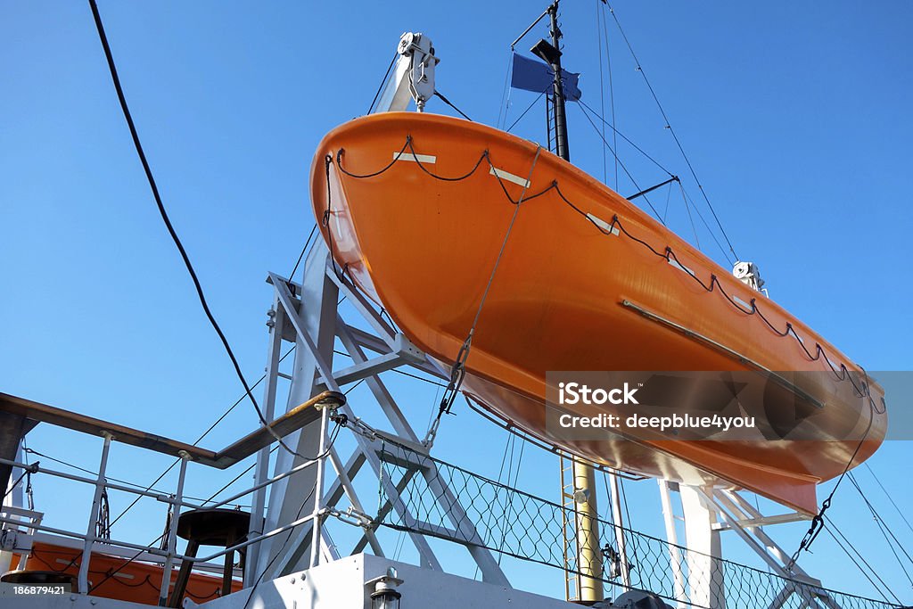 Barca di salvataggio su nave da crociera contro Blu cielo - Foto stock royalty-free di Abbassare