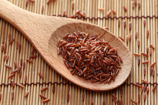 Red rice in a wooden spoon. Close-up.Please see:
