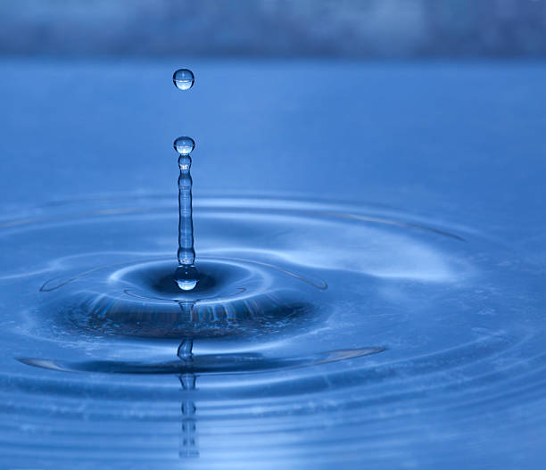 istock Dripping Water Droplets Splash On Blue Pond Surface, Rippling Out 186880235