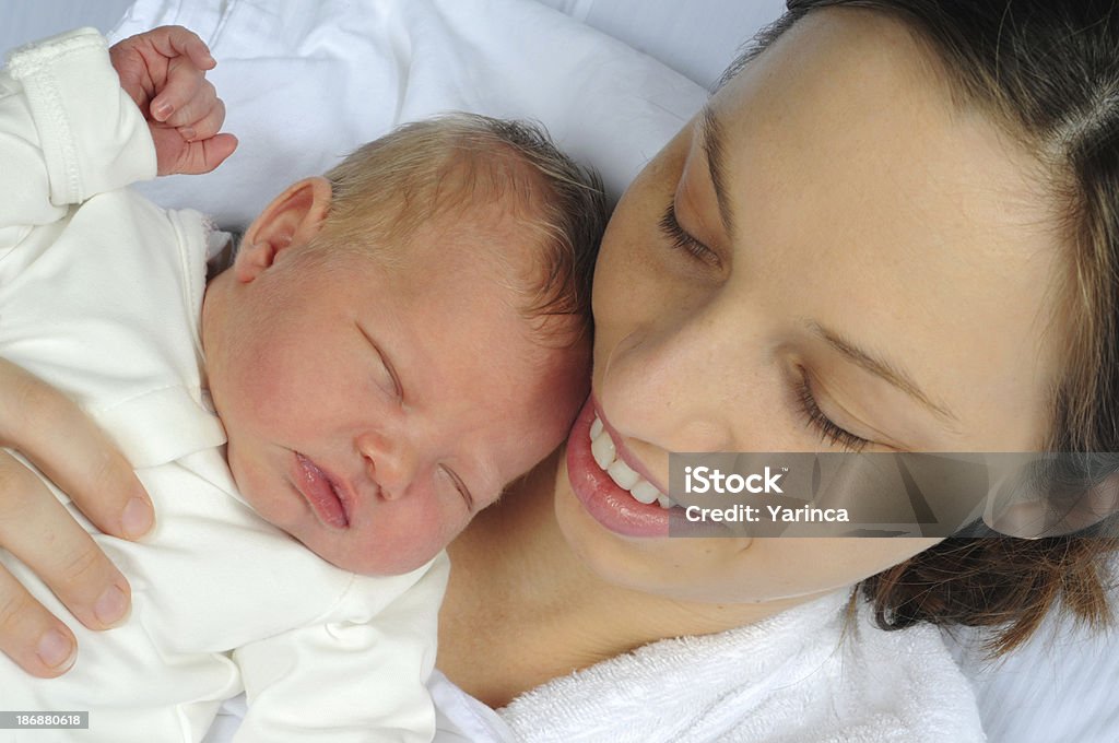 Mom and Newborn Mother holding her sleeping newborn. Hospital Stock Photo