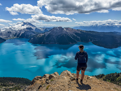 Young woman hiker looking at Garibaldi Lake from Panorama Ridge in summer in Squamish, BC, Canada