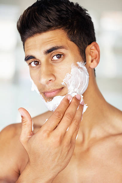 istock Attractive young man applying shaving cream to face 186881283