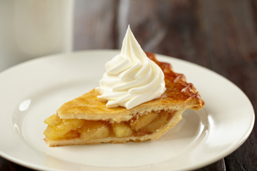 Tight shot of apple pie with a whipped cream and a cup ofcoffee on rustic wooden table.  Professionally shot, color corrected, exported 16 bit and retouched for maximum image quality. 