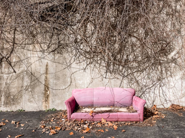 istock Old pink sofa abandoned in empty outdoor lot 1868821778
