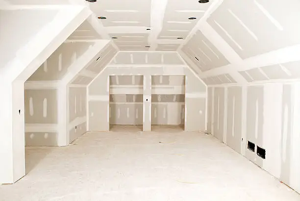 "A new bonus room, with complex angles, at a residential construction site with tape and mud on the drywall seams.A related image from my portfolio:"