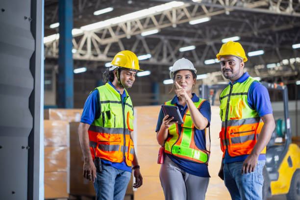istock Foreman workers working in warehouse talking about job, Warehouse worker team checking containers boxes, Workers team taking inventory in factory warehouse 1868833034