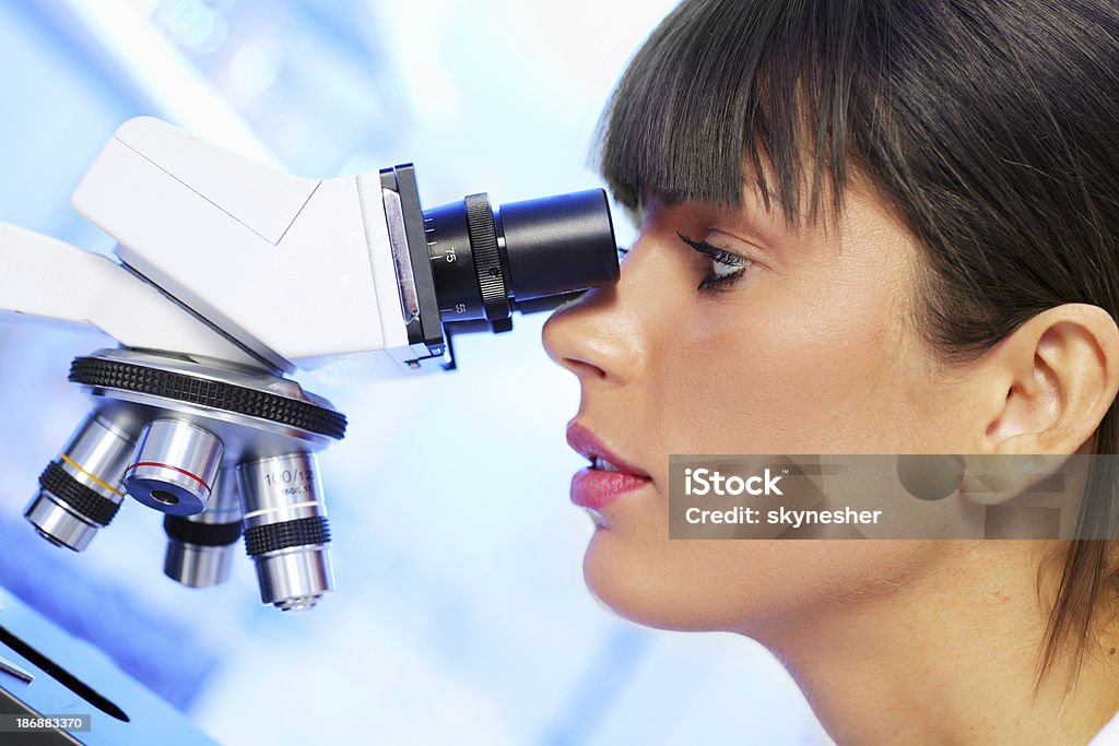 Naukowiec naukowiec Patrząc pod mikroskopem. - Zbiór zdjęć royalty-free (Badania)