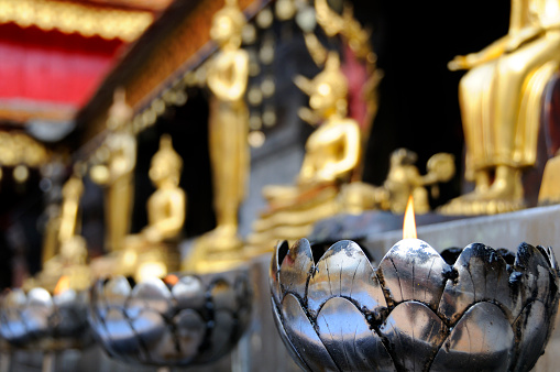 Candles with Buddhas behind. Taken at Wat Phrathat Doi Suthep, Chiang Mai.