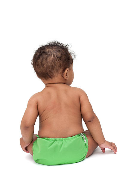 Baby in green cloth diaper from behind stock photo