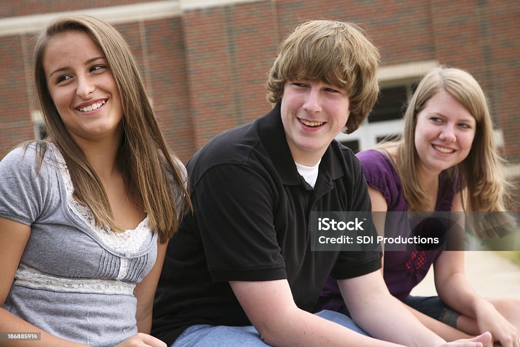 Três adolescentes felizes amigos se divertindo na escola - Foto de stock de Adolescente royalty-free