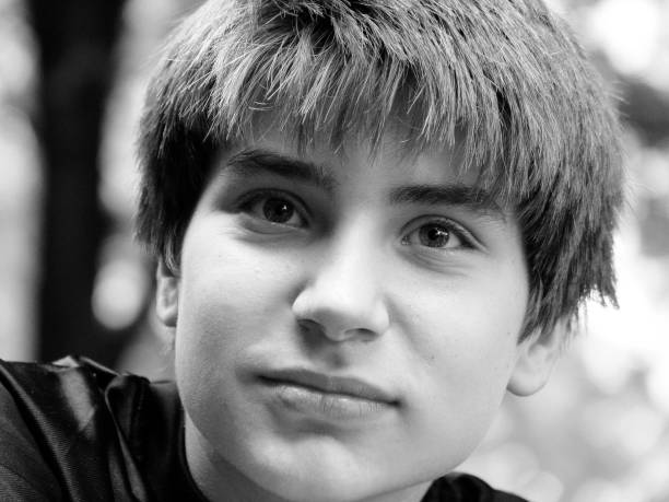 young blonde smiling guy portrait on black background - black and white photo